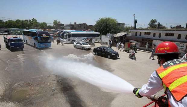 A worker sprays disinfectant at a bus terminal in Peshawar after the reopening of the public transport service.