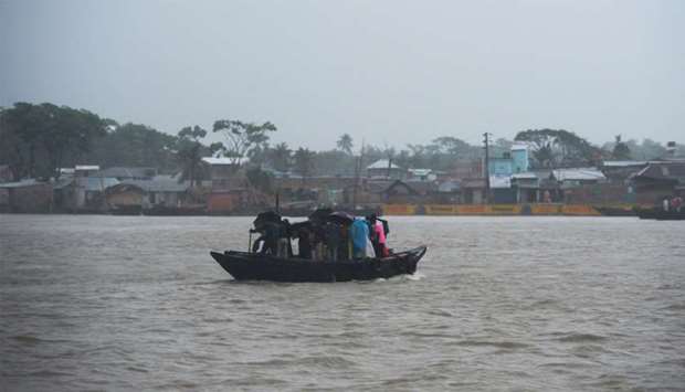 People cross a river on a boat ahead of the expected landfall of cyclone Amphan, in Khulna