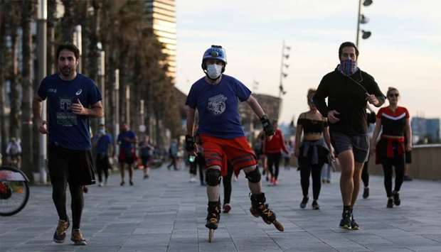 People exercise at the Barceloneta beach during the hours in which individual exercise is allowed outdoors, for the first time since the lockdown was announced, amid the coronavirus disease (COVID-19) outbreak, in Barcelona