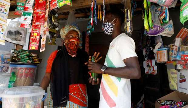 Shobowale Kehinde, 28, an entertainer who is visually impaired, buys a soft-drink bottle at a store in Iyawa area in Lagos.