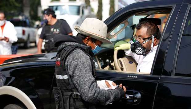 An employee of the municipality of Iztapalapa talks to the driver of a hearse, waiting to enter the San Nicolas Tolentino cemetery for the cremation of the body of a person who died of the coronavirus disease, in Mexico City.