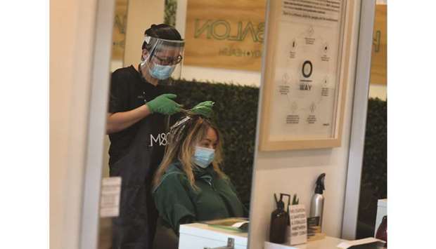 Son Chau works on the hair of Christina Renbic as the Katon Salon opens on May 12, 2020 in Fort Lauderdale, Florida. The hair salon reopened, approximately two months after shutting its doors due to the coronavirus pandemic, as Broward County starts the first phase of the states coronavirus pandemic reopening plan.