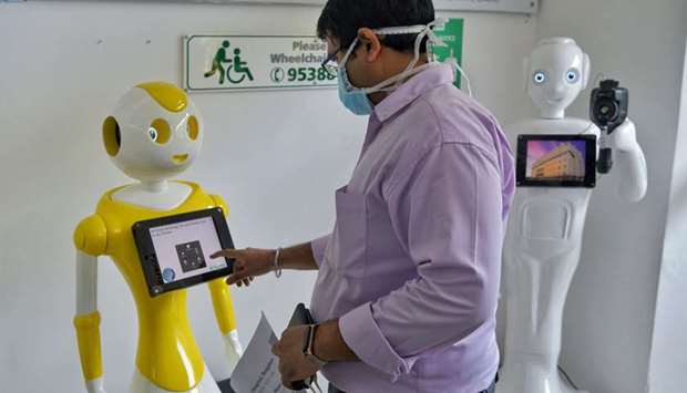 A hospital staff conducts tests on u2018Mitrau2019, a robot equipped with a thermal camera installed to register and conduct preliminary screening of patients before directing them to respective medical specialists to prevent the spread of coronavirus, at Fortis Hospital in Bengaluru yesterday.