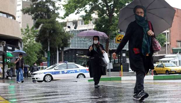 Iranians wear protective face masks, following the outbreak of the coronavirus disease, as they walk in Vali-E-Asr street, in Tehran, Iran on May 20