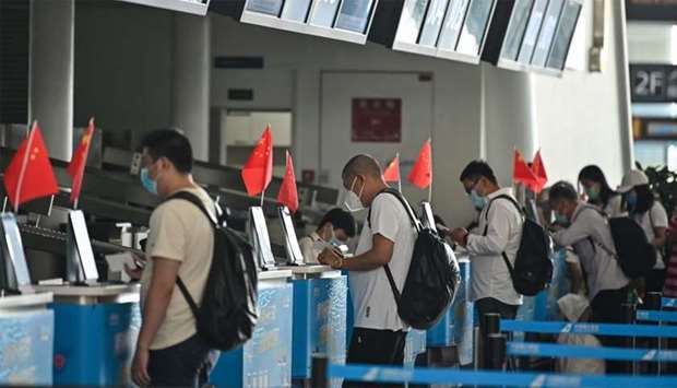 Passengers wearing face masks are seen at airline counters at Tianhe airport in Wuhan, in Chinau2019s central Hubei province