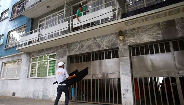 A man holds a blanket to collect food donations passed down from the balcony of an apartment as part of a programme to help low income households as the coronavirus outbreak continues in Mexico City, Mexico.