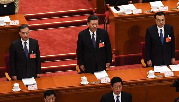 Chinese President Xi Jinping (centre), Premier Li Keqiang (right) and Politburo Standing Committee member Wang Yang (left) sing the national anthem during the opening session of the National Peopleu2019s Congress at the Great Hall of the People in Beijing. China faces u201cimmenseu201d economic challenges as it emerges from the coronavirus  pandemic, Li warned yesterday as he opened his nationu2019s annual legislative session that will seek to tighten Beijingu2019s control over Hong Kong.