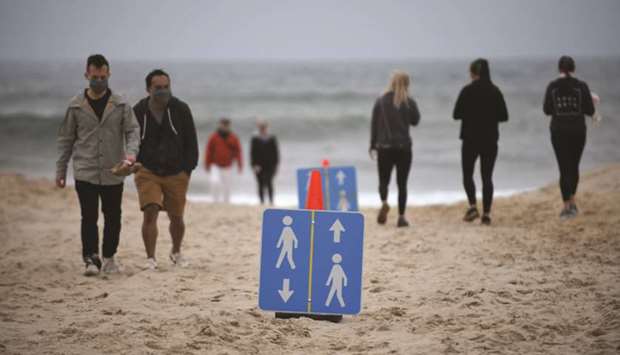 Signs are placed on the beach to direct people on how to keep social distance during Memorial Day weekend in Montauk, New York.