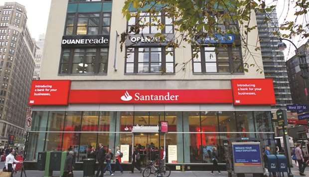 Pedestrians walk past a Banco Santander branch in New York. Banco Santander SAu2019s US subprime auto-loans unit has agreed to settle a dispute with 34 US states for more than $550mn, a blow to the stronger of its two businesses in the country.