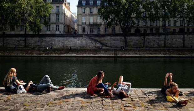 People in Paris enjoy the sunny weather yesterday on the banks of the river Seine.