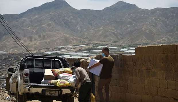 Volunteers carry relief aid for distribution to families who were victims of an attack by militants at a maternity ward, on the outskirts of Kabul on May 22. AFP