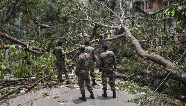 Soldiers cut trees to clear the roads in Kolkata yesterday.