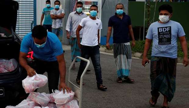 Migrant workers living in a factory-converted dormitory collect meals donated by charities for their Eid-al-Fitr celebrations amid the coronavirus disease outbreak in Singapore