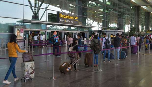 Passengers line up to enter the domestic departure lounge of the Bengaluru airport yesterday as domestic flights resumed after the government eased a lockdown imposed as a preventive measure against the spread of the coronavirus.
