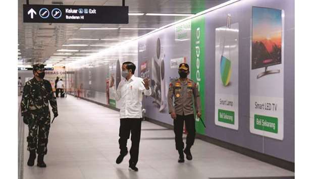 Indonesian President Joko Widodo (centre) wearing a face mask visits an MRT station in Jakarta yesterday, to inspect measures the capital city is implementing amid concerns of the coronavirus outbreak.