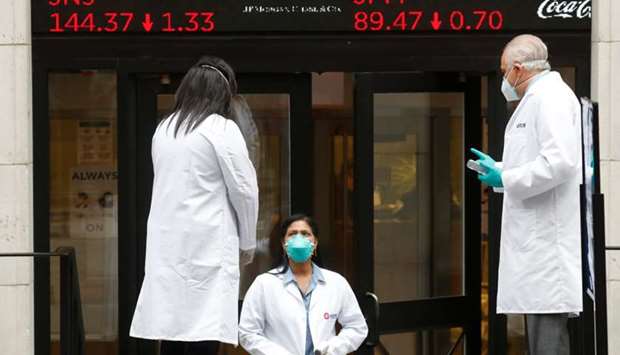 Medical personnel wear protective masks outside the New York Stock Exchange as the building opens for the first time since March while the outbreak of the coronavirus disease (COVID19) continues in the Manhattan borough of New York, U.S.