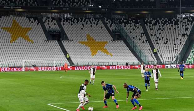 In this file photo taken on March 08, 2020 Juventus' Brazilian forward Douglas Costa (L) vies with Inter Milan's Italian midfielder Nicolo Barella (C) and Inter Milan's English midfielder Ashley Young in an empty stadium due to the novel coronavirus outbreak during the Italian Serie A football match Juventus vs Inter Milan, at the Juventus stadium in Turin