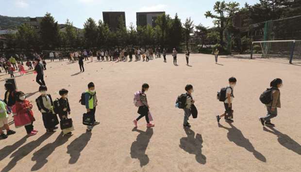 Students arrive as they keep social distance amid the coronavirus disease outbreak at an elementary school in Seoul, South Korea.