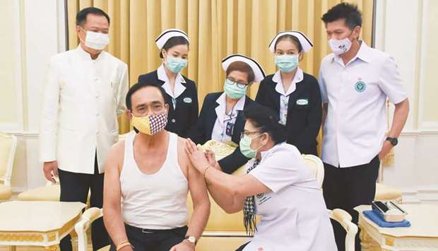 Thailandu2019s Prime Minister Prayut Chan-O-Cha (front left) receiving an influenza vaccine injection in Bangkok, as Health Minister Anutin Charnvirakul (back left) watches. Prayut pleaded for the swift passage of the 1.9tn baht ($59.6bn) stimulus package, saying the administration was currently attempting to manage the economy u201cusing the central budget, the next yearu2019s budget, or transferringu201d from other areas. u201cBut it is not enough.u201d