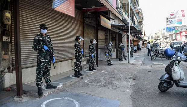 Security personnel stand guard outside shops closed by police personnel because customers were not maintaining social distancing after the government eased a lockdown imposed as a preventive measure against the Covid-19 coronavirus, in Ahmedabad.