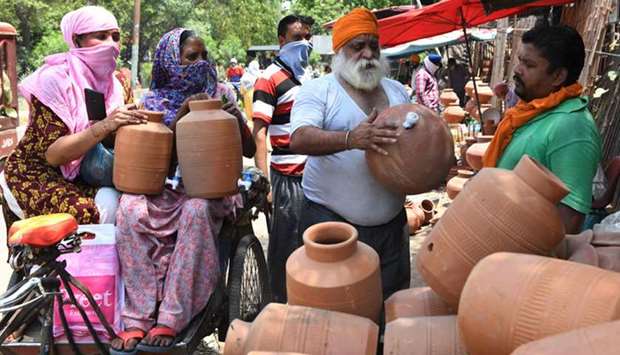 A vendor sells earthen pots to store and cool drinking water at a roadside stall in Amritsar.