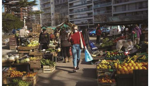 People shop at a produce market in Montevideo.