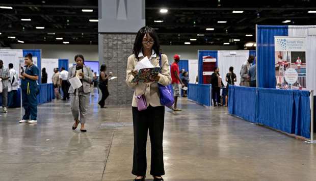 A job seeker views paperwork for attending companies during a job fair in Washington, DC. Continuing jobless claims, which tally Americansu2019 ongoing benefit claims in state programs, fell to 21.1mn for the week ended May 16, Labour Department figures showed yesterday.