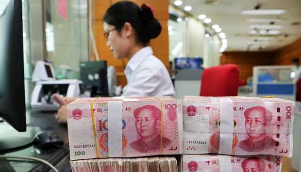 An employee counts 100-yuan notes at a bank in Nantong in Chinau2019s eastern Jiangsu province.