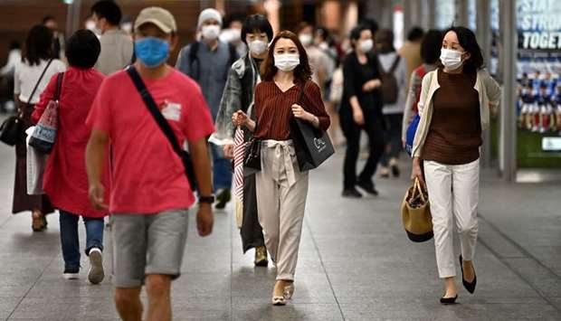 People wearing face masks walk at the Yokohama train station yesterday. Japan on Wednesday announced more than $1tn of extra help for households and businesses, while the European Commission unveiled a package worth as much u20ac750bn ($825bn) to help the continentu2019s worst-hit economies.