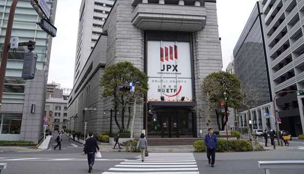 Pedestrians walk by the Tokyo Stock Exchange building. The Nikkei 225 closed down 0.2% to 21,877.89 points yesterday.