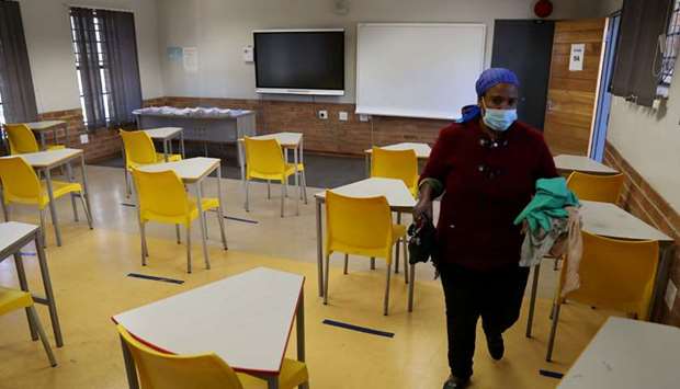 A worker walks past safely spaced desks following safe distancing measures amid the spread of the coronavirus disease (Covid-19) outbreak, at the Seshegong secondary school in Olivenhoutbosch, South Africa.