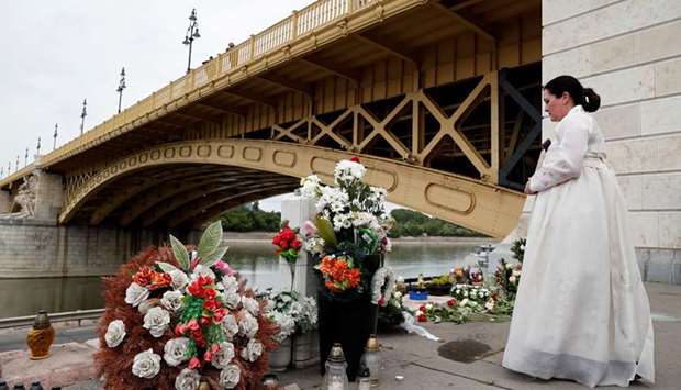 A woman in a hanbok mourns the victims on the 1st anniversary of the Mermaid boat accident near Margaret bridge, at the Danube river, in Budapest.
