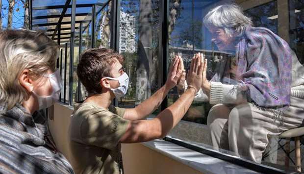 Brazilian Alexandre Schleier speaks with his 81-year-old grandmother Olivia Schleier next to his mother Eunice Schleier through a window at the Premier Hospital, in Sao Paulo, Brazil. The hospital does not have any case of Covid-19 but does not permit visits to prevent contagions of the new coronavirus.