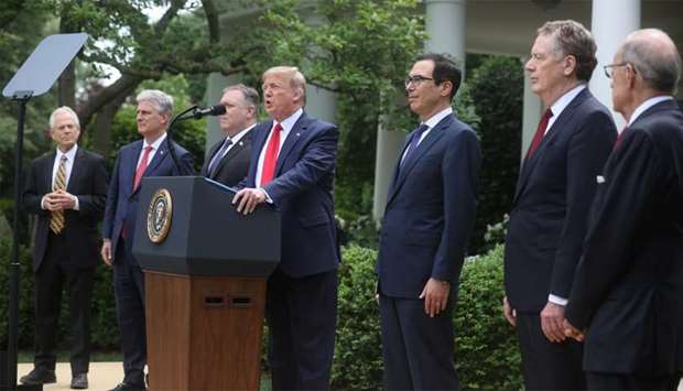 US President Donald Trump stands with members of his Cabinet as he makes an announcement about US trade relations with China and Hong Kong in the Rose Garden of the White House in Washington