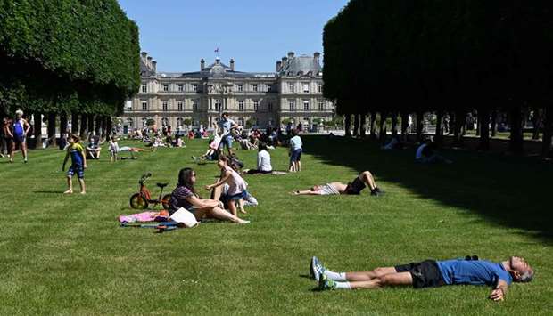 People lie and sit under the sun on the lawns of Parisu2019s Jardin du Luxembourg park, on the first day of reopening following the nationwide lockdown put into place on March 17, to stop the spread of the novel coronavirus.