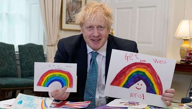 Britain's Prime Minister Boris Johnson displaying his Get Well Soon cards sent in by children while he was ill with the novel coronavirus