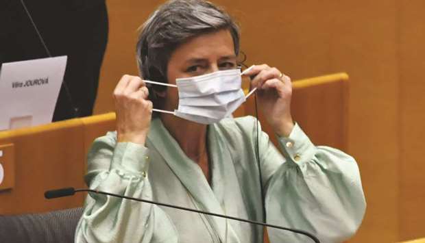 Margrethe Vestager, competition commissioner of the European Commission, puts on a protective face mask in the hemicycle of the European Parliament in Brussels.