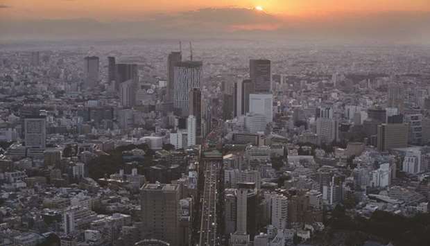 Commercial and residential buildings stand as the sun sets in Tokyo. Staring at a record debt issuance this fiscal year, traders in Japanu2019s sovereign bond market are signalling that the $2tn deluge will flatten the nationu2019s yield curve.