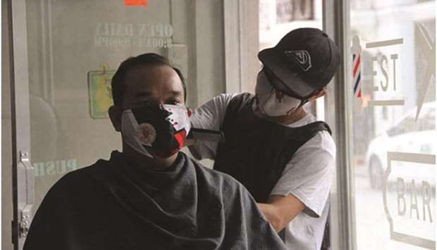 Barber Gerald Averila trims the hair of shop owner Bertsan Balanay at the Barberto Shop in Intramuros, Manila, a little over a week before similar establishments are allowed to operate from June 7.