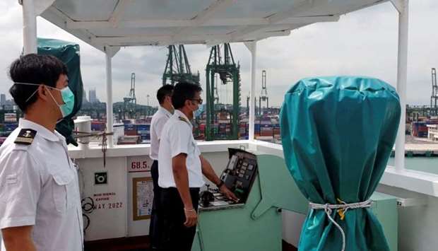 A crew member wearing a protective face mask sounds the horn of their boat, as all working ships sound their horns at noon during the outbreak of the coronavirus disease, in Singapore