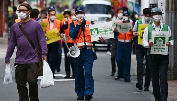 Municipal employees patrol a street asking people to stay home amid the COVID-19 coronavirus outbreak in Tokyo