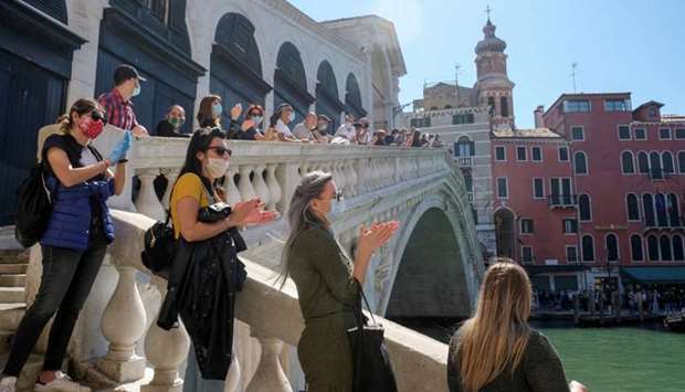 A rally organised by small business owners stops by the Rialto bridge to commemorate the health care workers who died amid the outbreak, as Italy begins a staged end to a nationwide lockdown due to a spread of the coronavirus disease, in Venice, Italy