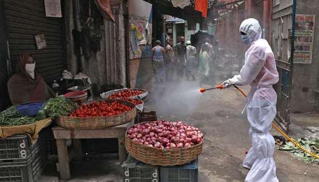 A municipal worker sprays disinfectant in a market in Kolkata yesterday.