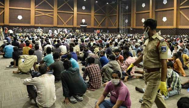 Stranded migrant workers sit in a waiting hall before registering with police officials for a movement pass to be able to return to their hometowns after the government eased a nationwide lockdown imposed as a preventive measure against the COVID-19 coronavirus, on the outskirts of Hyderabad
