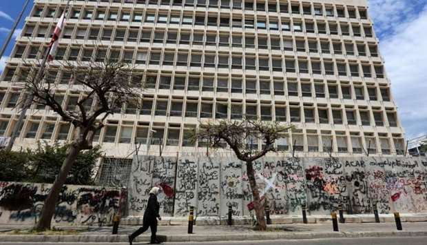 A woman wearing a protective mask walks past Central Bank building as Lebanon extends a shutdown to curb the spread of the coronavirus disease (COVID-19) in Beirut, Lebanon