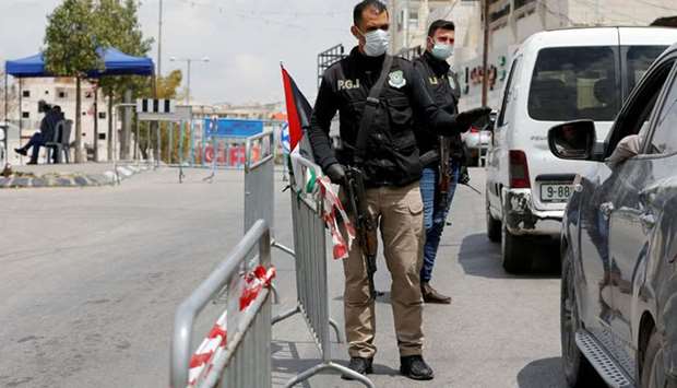 Members of Palestinian security forces stand guard at a checkpoint as Palestinian President Mahmoud Abbas extended to June 5 a state of emergency in response to the coronavirus crisis, in Hebron in the occupied West Bank, yesterday.