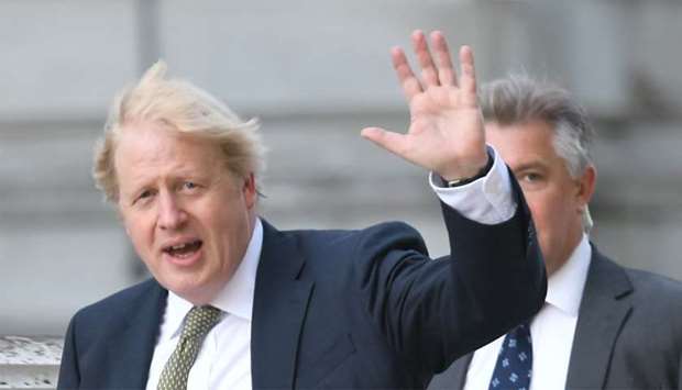 Britain's Prime Minister Boris Johnson waves as he takes a morning walk in central London