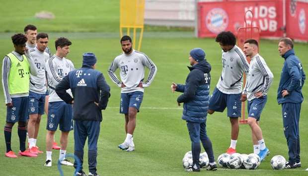 Bayern Munichu2019s head coach Hansi Flick (centre) talks to his players during a training session in Munich yesterday. (AFP)