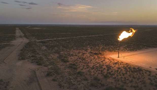 A gas flare burns at dusk in the Permian Basin in Texas, US (file). The historic rout in crude prices amid the Covid-19 pandemic has spurred an unprecedented retreat from shale exploration.