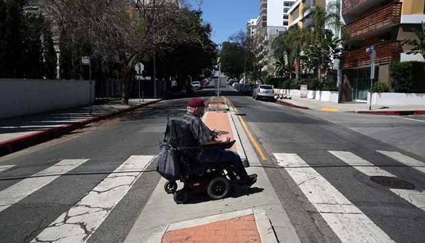 OLD AGE VAGARIES: Gregory Kuhl, 69, returns to his street after shopping at Sprouts in Hollywood last month in Los Angeles, California. Sometimes there are major cracks in the pavement, cars in peoples driveways or levelling issues that make navigating his route difficult.